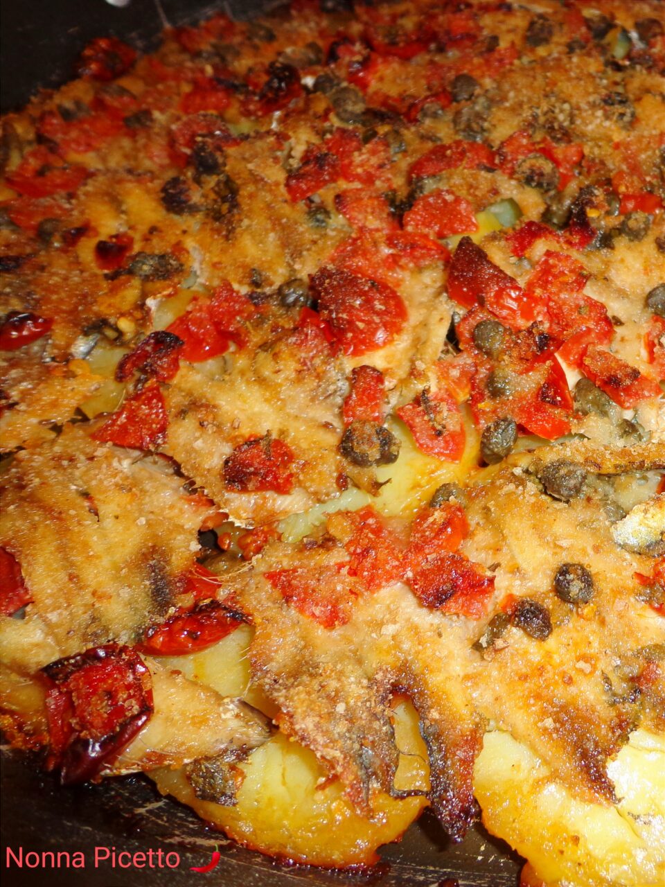 Alici in tortiera con patate, pomodorini e capperi gratinate al forno