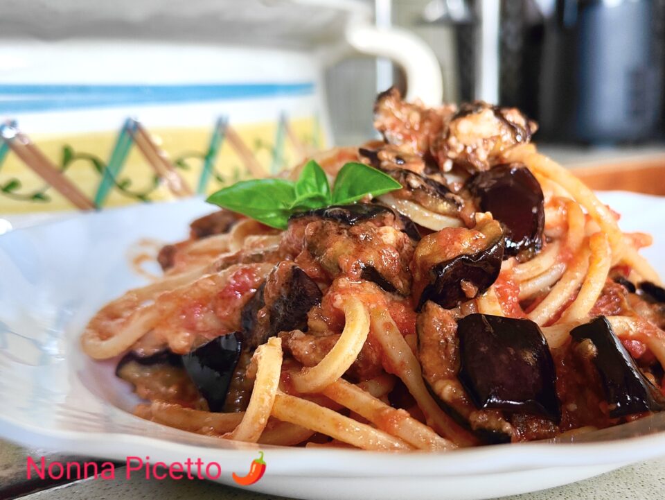 La pasta alla Norma condita con un buon sugo di pomodoro semplice al basilico, melanzane fritte a cubetti e una grattugiata di ricotta di pecora stagionata, preparata con la ricetta di Nonna Picetto è buonissima, offre i sapori e profumi dell'estate. Puoi usare lo stesso procedimento per fare la pasta alla siciliana o un sontuoso timballo di pasta.