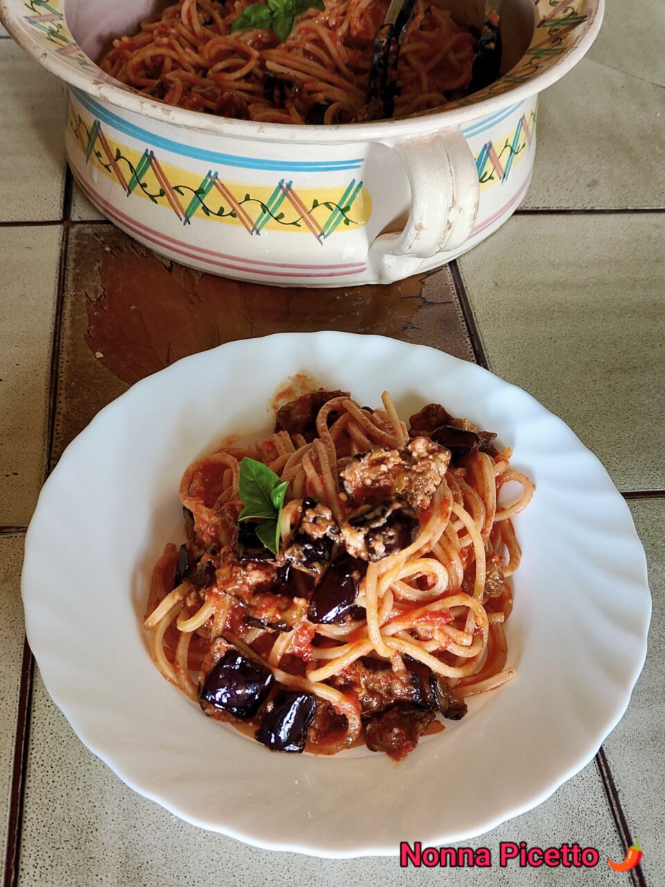 La pasta alla Norma condita con un buon sugo di pomodoro semplice al basilico, melanzane fritte a cubetti e una grattugiata di ricotta di pecora stagionata, preparata con la ricetta di Nonna Picetto è buonissima, offre i sapori e profumi dell'estate. Puoi usare lo stesso procedimento per fare la pasta alla siciliana o un sontuoso timballo di pasta.