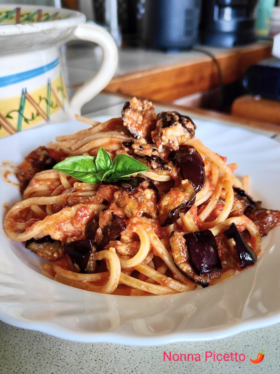 La pasta alla Norma condita con un buon sugo di pomodoro semplice al basilico, melanzane fritte a cubetti e una grattugiata di ricotta di pecora stagionata, preparata con la ricetta di Nonna Picetto è buonissima, offre i sapori e profumi dell'estate. Puoi usare lo stesso procedimento per fare la pasta alla siciliana o un sontuoso timballo di pasta.